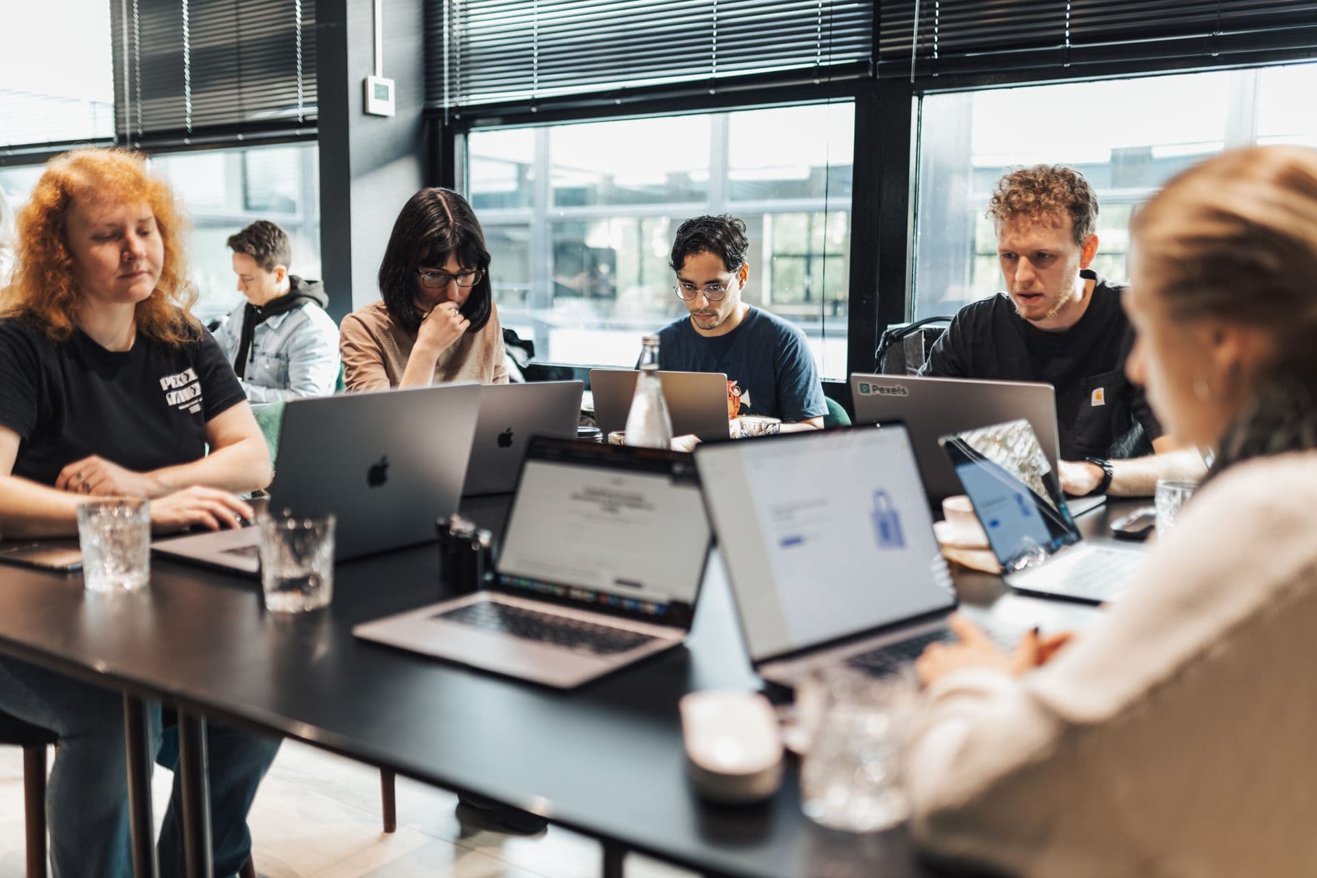 Team of professionals collaborating on laptops in a modern office